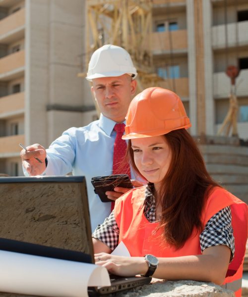 White-collar workers wearing protective helmet works on the building site